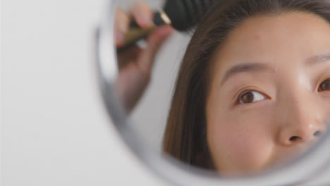 Close-Up-Shot-of-Young-Woman-Brushing-Hair