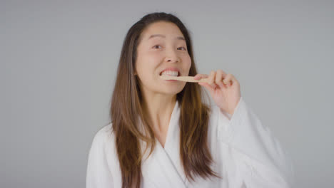 Mid-Shot-of-Woman-Brushing-Teeth-and-Smiling