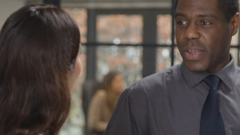 Over-the-Shoulder-Shot-of-Man-and-Woman-Talking-at-Work