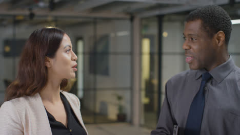 Mid-Shot-of-Male-and-Female-Colleague-Talking