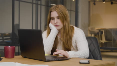 Long-Shot-of-a-Young-Woman-Tired-on-Computer-at-Work