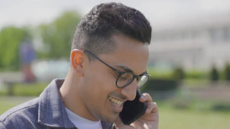 CU-Tilt-Up-Shot-of-Male-Student-Answering-Phone-in-College-Park