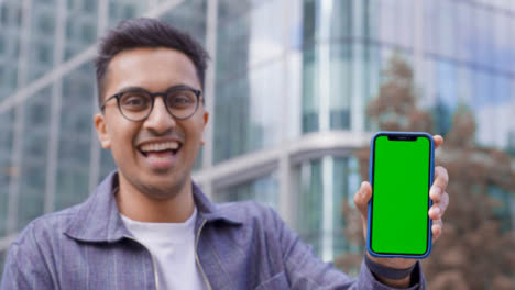 Low-Angle-Shot-of-Young-Man-Holding-Green-Screen-Smartphone