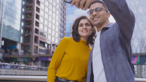 Tiro-De-ángulo-Bajo-De-Amigos-Tomando-Selfie-En-La-Ciudad