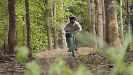Slow-Motion-Shot-Of-Man-On-Mountain-Bike-Making-Mid-Air-Jump-On-Dirt-Trail-Through-Woodland-4