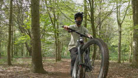 Drone-Tracking-Man-On-Mountain-Bike-Cycling-Along-Trail-Through-Countryside-And-Woodland-2