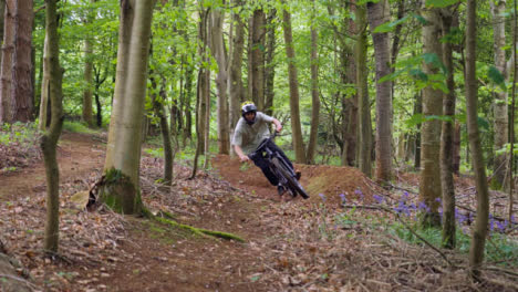 Man-On-Mountain-Bike-Cycling-Along-Trail-Through-Countryside-And-Woodland