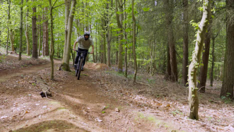 Man-On-Mountain-Bike-Cycling-Along-Trail-Through-Countryside-And-Woodland-2