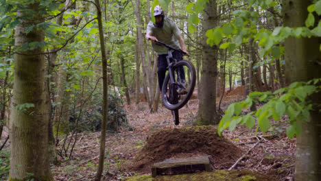 Slow-Motion-Shot-Of-Man-On-Mountain-Bike-Making-Mid-Air-Jump-On-Dirt-Trail-Through-Woodland-6