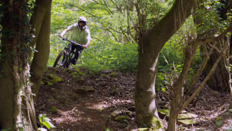 Slow-Motion-Shot-Of-Man-On-Mountain-Bike-Making-Mid-Air-Jump-On-Dirt-Trail-Through-Woodland-10