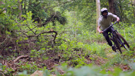 Zeitlupenaufnahme-Eines-Mannes-Auf-Dem-Mountainbike,-Der-Auf-Dem-Weg-Durch-Den-Wald-Radelt