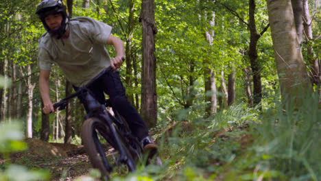 Slow-Motion-Shot-Of-Man-On-Mountain-Bike-Making-Mid-Air-Jumps-On-Dirt-Trail-Through-Woodland-2