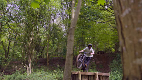 Slow-Motion-Shot-Of-Man-On-Mountain-Bike-Making-Mid-Air-Jumps-On-Dirt-Trail-Through-Woodland-7