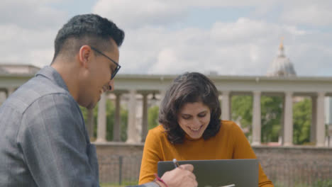 Handheld-Shot-of-Two-Students-Working-In-Park