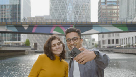 Handheld-Shot-of-Friends-Taking-a-Selfie-In-City