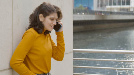 Pull-Focus-Shot-of-Young-Woman-Having-Phone-Call
