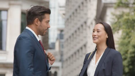 Businesswoman-And-Businessman-Having-Informal-Meeting-Outside-Offices-2