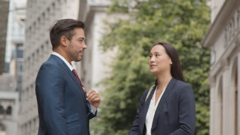 Businesswoman-And-Businessman-Having-Informal-Meeting-Outside-Offices-3