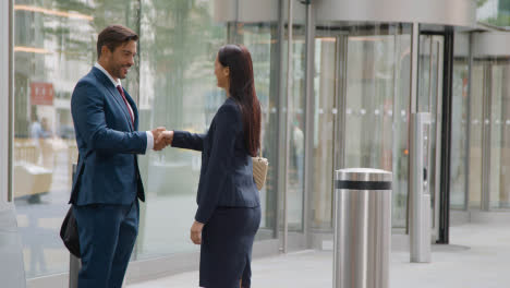 Businesswoman-And-Businessman-Meeting-And-Shaking-Hands-Outside-Office-London-City-Office