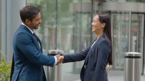 Businesswoman-And-Businessman-Meeting-And-Shaking-Hands-Outside-Office-London-City-Office-1