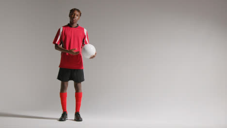 Studio-Portrait-Of-Young-Male-Footballer-Wearing-Club-Kit-With-Ball-Under-Arm-2