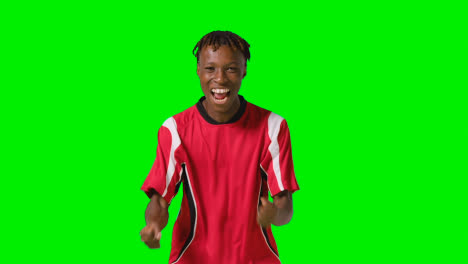 Portrait-Of-Young-Male-Footballer-Wearing-Club-Kit-Celebrating-Goal-Against-Green-Screen