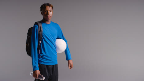 Studio-Portrait-Of-Young-Man-Playing-Football-Or-Other-Sport-Walking-To-Training-With-Kit-Bag-1
