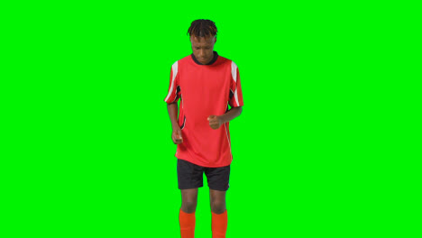 Studio-Shot-Of-Young-Male-Footballer-Warming-Up-With-Exercises-Before-Game-Against-Green-Screen-1