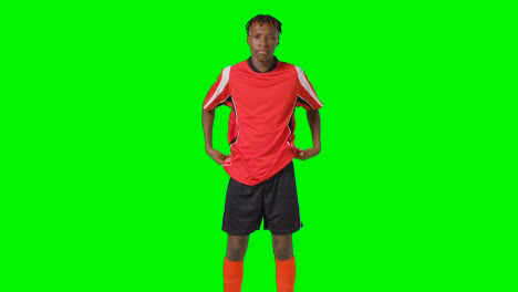 Studio-Shot-Of-Young-Male-Footballer-Warming-Up-With-Exercises-Before-Game-Against-Green-Screen-2