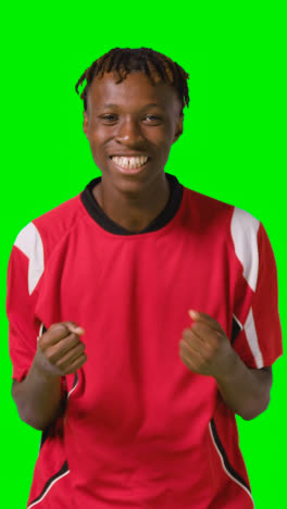 Vertical-Video-Of-Young-Male-Footballer-Wearing-Club-Kit-Celebrating-Goal-Against-Green-Screen-