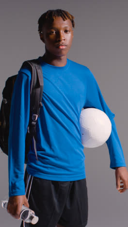 Retrato-De-Estudio-De-Video-Vertical-De-Un-Joven-Entrenando-Para-Fútbol-Con-Bolsa-Y-Pelota