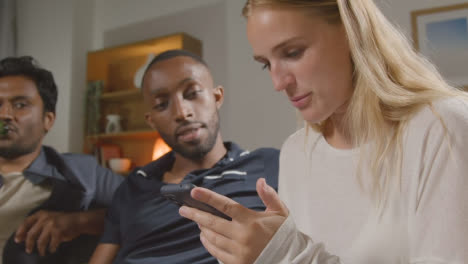 Multi-Cultural-Friends-Ordering-Takeaway-Food-Delivery-On-Mobile-Phone-Sitting-On-Sofa-At-Home-Together-2