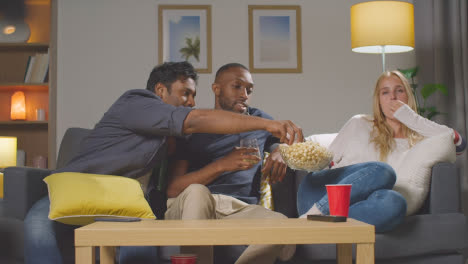 Multikulturelle-Freunde,-Die-Zu-Hause-Auf-Dem-Sofa-Sitzen,-Fernsehen,-Popcorn-Essen-Und-Bier-Trinken-1
