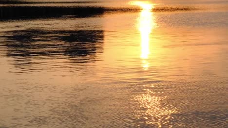 Sunset-golden-Reflexion-des-Sonnenlichts-im-Wasser,-Sonnenuntergang-über-Wellen-Fluss