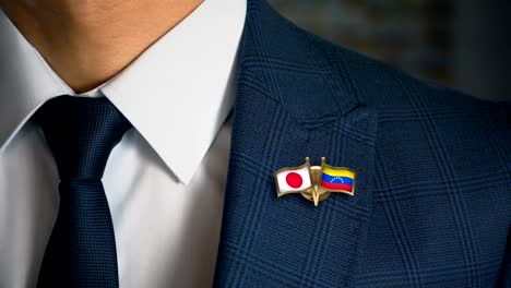 Businessman-Walking-Towards-Camera-With-Friend-Country-Flags-Pin-Japan---Venezuela