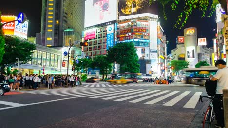 Shibuya-district-at-night-with-crowd-passing-crosswalk.-Tokyo,-Japan.-4K-Timelapse