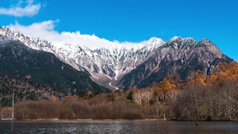 Montaña-de-la-tapa-del-Timelapse-Snow,-Kamikouchi,-charca-de-Taisho-ike-y-los-Alpes,-Japón