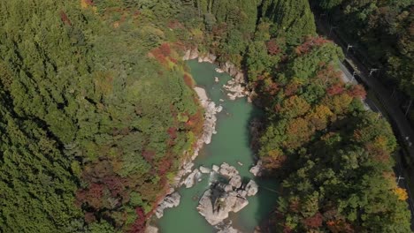 Aerial-view-of-Kinugawa-river-and-autumn-foliage-at-Kinugawa-Onsen-hot-springs,-Nikko,-Japan