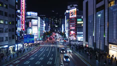 Lapso-de-tiempo-de-muchos-vehículos-y-gente-que-viaja-por-una-carretera-en-Shinjuku-Tokyo-por-la-noche.-Shinjuku-es-un-importante-centro-comercial,-la-estación-de-tren-más-concurrida-en-el-mundo.