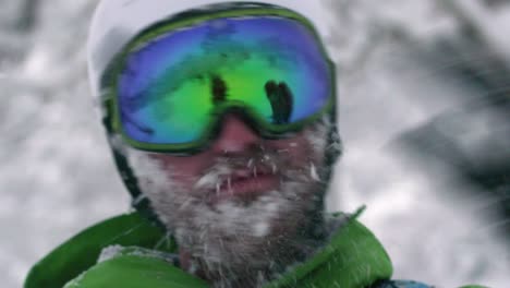 Snowboarder-esquiador-Mountainman-usar-casco-grande-barba-llena-de-nieve-sacudiendo-la-cara-congelada