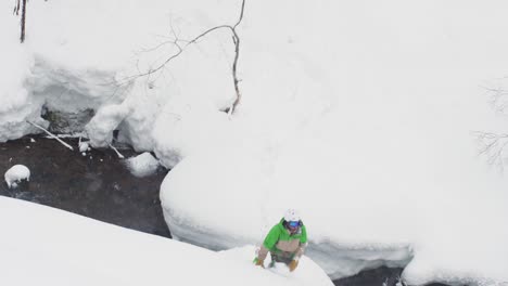 Snowboarder-peligroso-salto-sobre-Río-profundo-polvo-nieve-japonés-montañas