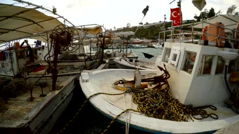 boats-in-a-fishing-bay-in-the-outback-of-the-Mediterranean-Sea-close-up,-Turkish-flags-in-the-wind