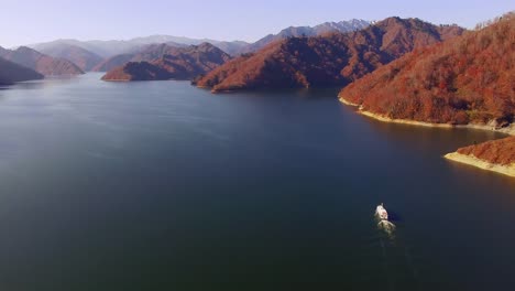 Aerial---Late-autumn-lakes-and-sightseeing-boat-and-autumn-mountains