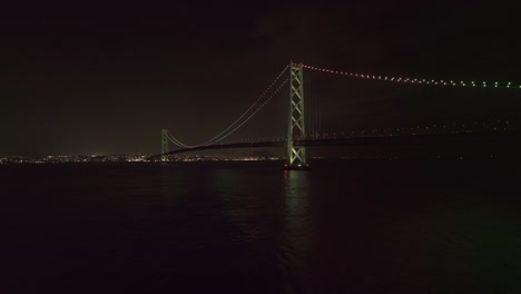 Aérea-ascendente---Puente-Akashi-Kaikyo-de-noche-vista-desde-la-isla-de-Awaji