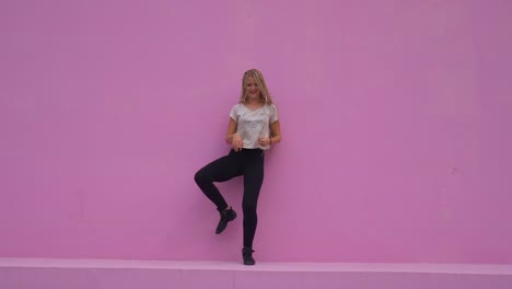 Casual-girl-with-braided-hair-having-fun-and-silly-dancing-over-pink-background