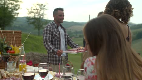 Group-of-friends-doing-a-bbq-in-the-countryside-together.-shot-in-slow-motion