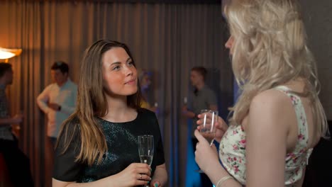 Two-girls-gossiping-with-glasses-of-sparkled-wine