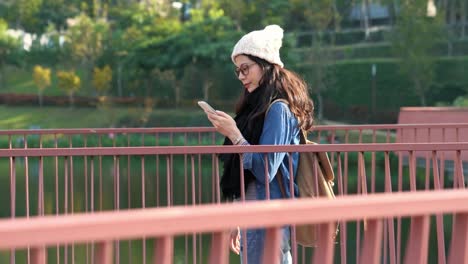 Asian-girl-texting-message-and-walking