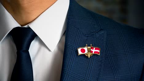 Geschäftsmann-zu-Fuß-in-Richtung-Kamera-mit-Freund-Land-Flaggen-Pin-Japan---Dänemark