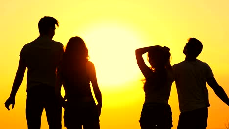 The-silhouettes-of-dancing-people-on-the-background-of-the-sunrise.-slow-motion